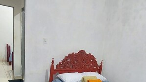 Un dormitorio con cama, ventilador, alfombra y espejo.
