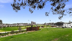 A grassy field with a building in the background. - Designer 1-Bed Apartment with Balcony (Rozelle)