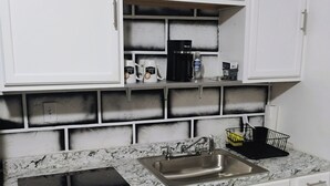 A kitchen with white cabinets, a granite countertop, a double sink, and a coffee maker. - WALKING DISTANCE FROM HARD ROCK STADIUM
1-bedroom apartment Miami Gardens (Miami Gardens)