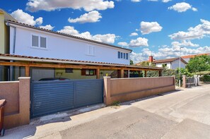 A two-story house with a gated entrance, a covered porch, and a clear blue sky. - Apartment 2436/208293 (Istria - Valbandon), 1500m from the beach (Valbandon)