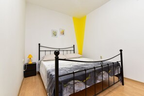 A bedroom with a bed, a nightstand, a lamp, and a wall with two framed pictures. - Apartment 2436/208293 (Istria - Valbandon), 1500m from the beach (Valbandon)