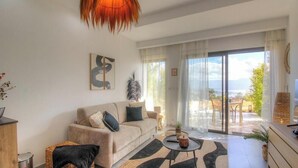 Ein Wohnzimmer mit einer Couch, einem Couchtisch und Blick durch die Glastür.