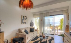 Ein Wohnzimmer mit einer Couch, einem Couchtisch und Blick durch die Glastür.