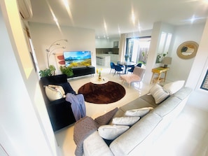Ein modernes Wohnzimmer mit einer Couch, einem Couchtisch und einem Fernseher.