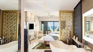 A modern hotel room with a large bed, a sitting area, a bathroom with a bathtub, and a large mirror. - Luxurious All-inclusive 2BR Suite at Garza Blanca Cancun  Thanksgiving Week 2026 (Cancún)