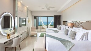 A hotel room with a bed, a desk, a chair, a large mirror, and a view of the sea. - Luxurious All-inclusive 2BR Suite at Garza Blanca Cancun  Thanksgiving Week 2026 (Cancún)