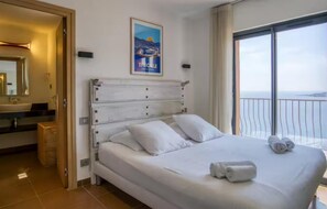 Ein Hotelzimmer mit Bett, Bad und Balkon mit Aussicht.