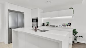 Una cucina moderna con isola centrale, elettrodomestici in acciaio inossidabile e un design minimalista.