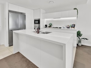 Eine moderne Küche mit einer zentralen Kochinsel, Edelstahlgeräten und einem minimalistischen Design.
