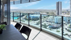 Un balcone con vista su un panorama urbano, che include grattacieli e una rotonda.