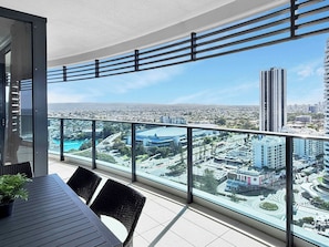 Ein Balkon mit Blick auf eine Stadtlandschaft, darunter Wolkenkratzer und ein Kreisverkehr.