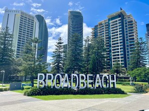 Ein Schild für Victoria Park und Broad Beach, umgeben von modernen Hochhäusern.