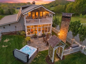 Ein zweistöckiges Haus mit Balkon, Whirlpool und Kamin aus Stein.
