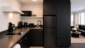 A modern kitchen with a black refrigerator, a microwave, a coffee maker, and a sink. - Central CBD | Walk to Te Pae, Stadium + Parking (Christchurch)