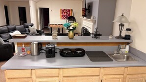 A modern kitchen with a built-in island, a coffee maker, a toaster, a blender, and a sink. - Welcoming 2-bedroom basement apartment with AC in vibrant Atlanta (Atlanta)