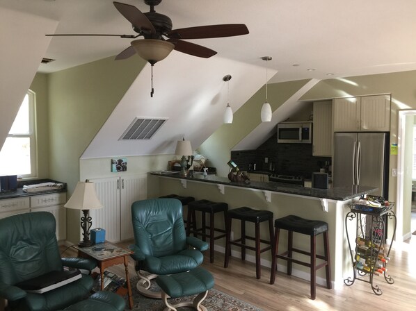 A modern kitchen with a ceiling fan, bar stools, and a wine rack. - New secluded apt nestled among the tall pines in charming Running Springs (Running Springs)