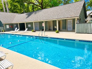 A swimming pool with lounge chairs, a covered area with doors, and a fence. - Golf View Condo - Pool Steps Away -  Beach Access (Hilton Head Island)