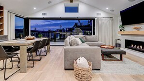 A spacious living area with a dining table, sofa, and fireplace. - South Bay Sweet Spot: Walk to Hermosa & MB Piers 5 bdrm home 2 Blocks from Beach (Hermosa Beach)