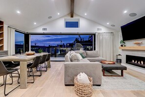 Un salón amplio con mesa de comedor, sofá y chimenea.