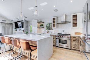 Una cucina moderna con isola centrale, elettrodomestici in acciaio inossidabile e mobili in legno.