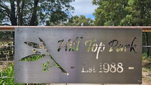 A sign for Hill Top Park with a tree design and the establishment year 1988. - Apple Tree Studio - country luxury self-contained studio (Kilmore)