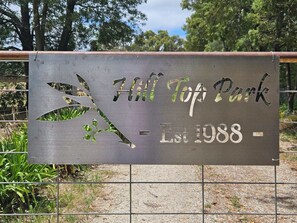 A sign for Hill Top Park with a tree design and the establishment year 1988. - Apple Tree Studio - country luxury self-contained studio (Kilmore)