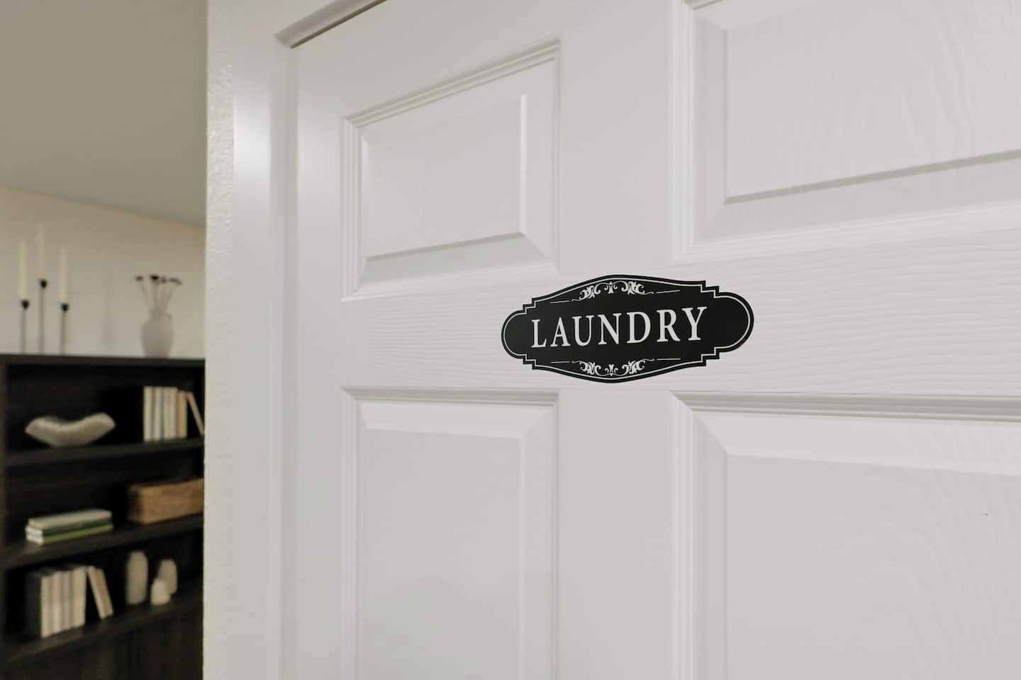 A white door with a black sign that reads 'LAUNDRY.'