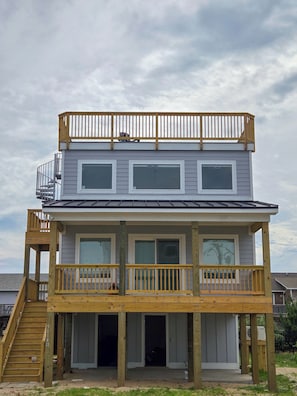 A two-story building with a balcony, a staircase, and a porch.