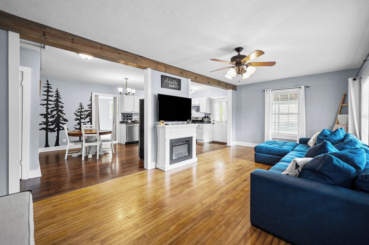 A modern living room with a fireplace, a blue sofa, and a television.