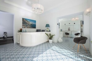 Eine moderne Küche mit einer weißen Kochinsel, blau gemustertem Boden und Pendelleuchten.