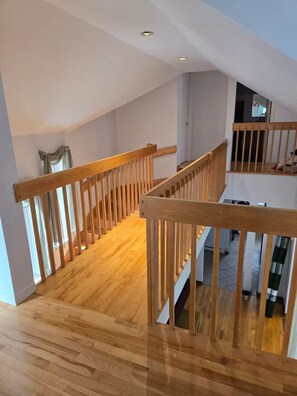 A wooden staircase with a railing, leading to an upper floor. - 6BedR with 7 beds Single house 3 private parking (Brossard)