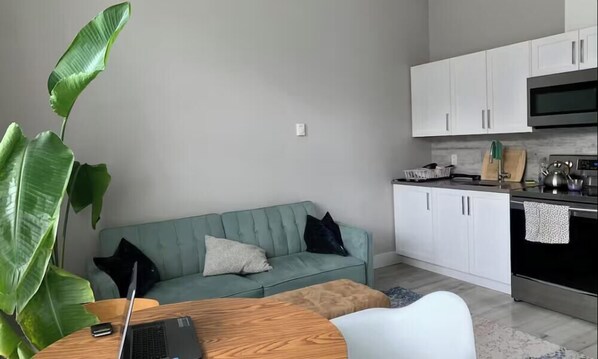 A modern kitchen with white cabinets, a microwave, and a stove. - Sooke Broomhill Abode (Sooke)