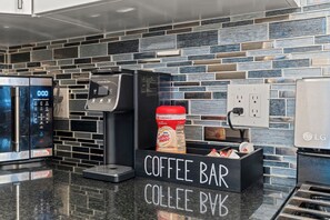 En kaffebar med en kaffemaskin som har företagets logotyp, en kaffekanna och en skylt som visar kaffebarens namn.