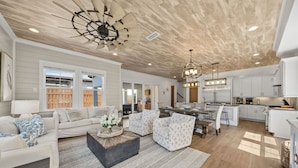 A spacious living area with a modern kitchen, a dining area, and a large window providing natural light. - Heated Pool~1/2 mile to Beach~Dogs OK~Fenced Yard (Santa Rosa Beach)
