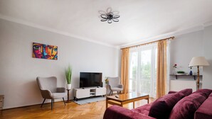 Uma sala de estar moderna com sofá, TV e um quadro na parede.