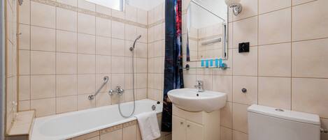 Un baño con bañera, lavamanos e inodoro.