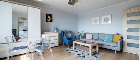 A modern living room with a sofa, chairs, a coffee table, and a mirror.