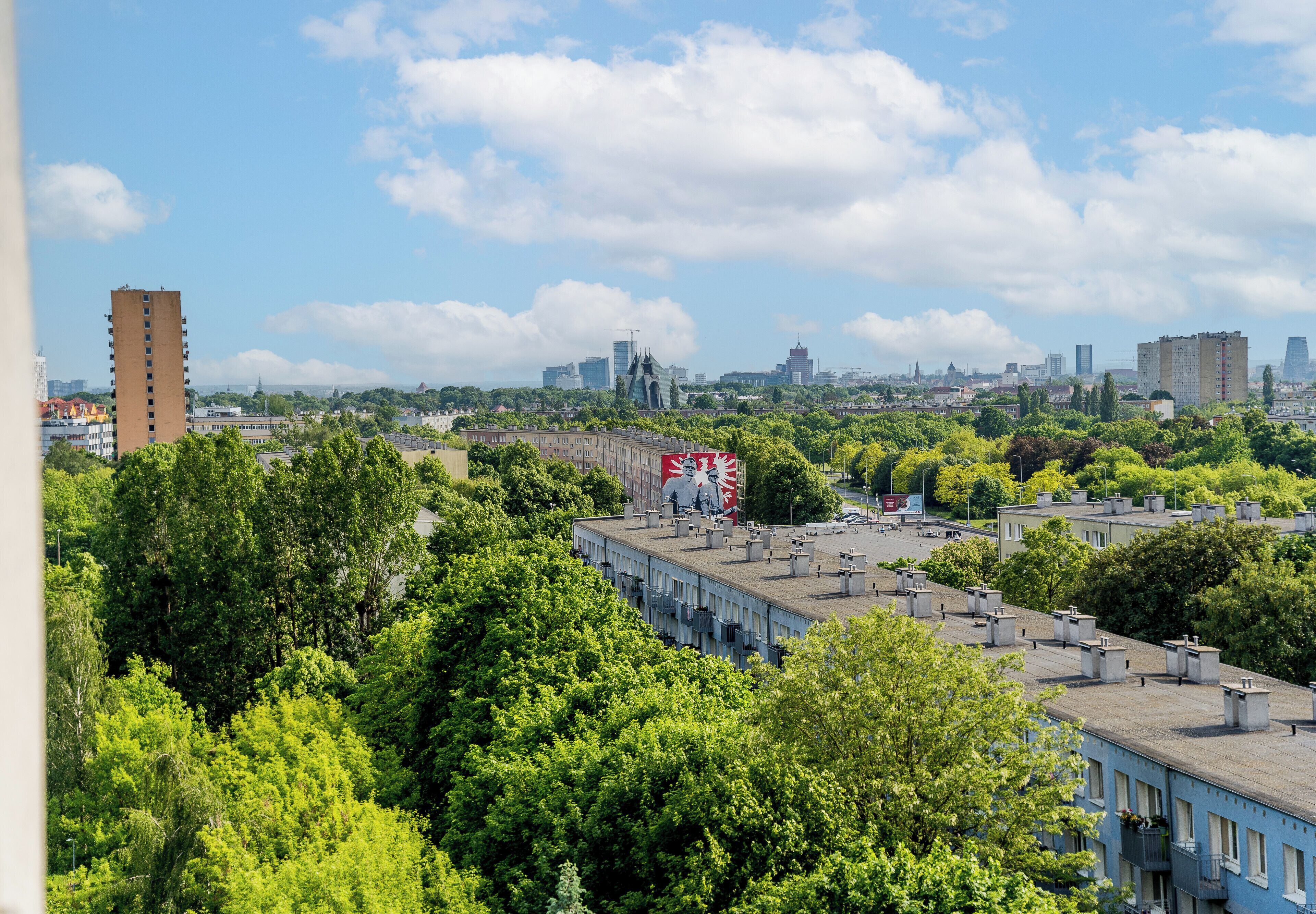 Une vue urbaine avec des bâtiments, des arbres et un ciel dégagé.