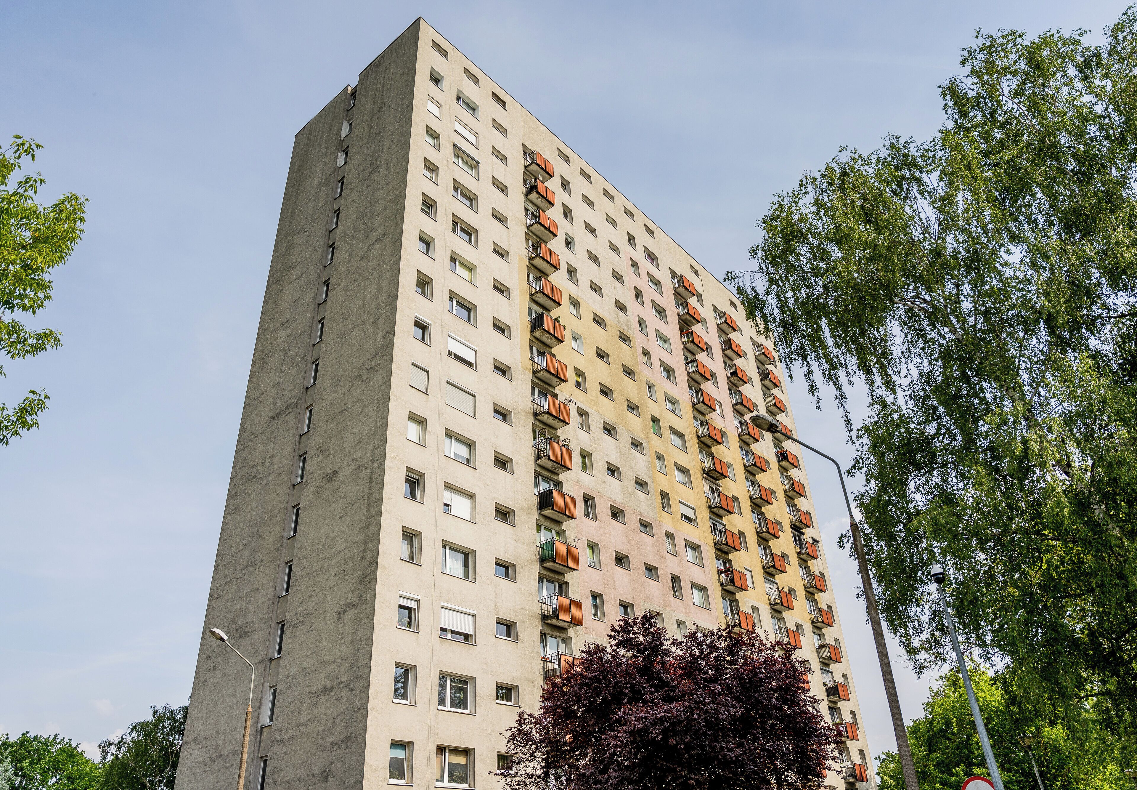 A tall residential building with multiple balconies and windows.