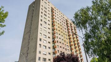 A tall residential building with multiple balconies and windows.