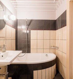 Un baño moderno con una bañera independiente, un lavamanos y una ducha.