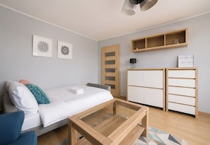 Een moderne slaapkamer met een bed, een bureau, een kledingkast en een plank.