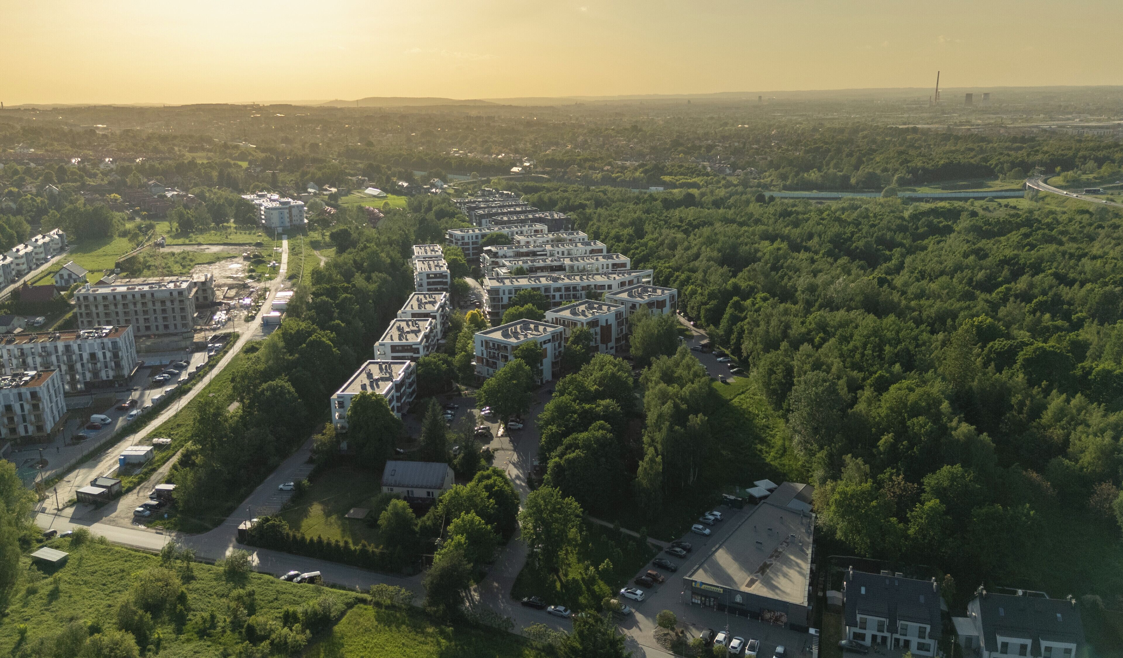 Luchtbeeld van een woongebied met appartementencomplexen, wegen en groen.