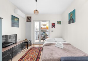 Quarto moderno com televisão, cama e obras de arte.