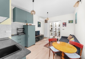 Un espace de vie compact comprenant une cuisine, un coin repas et un coin salon.
