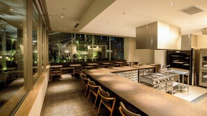 Una cucina moderna con un lungo bancone, sgabelli da bar e un piano cottura integrato.