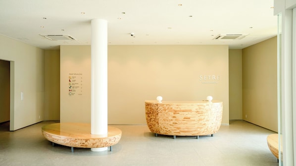 A reception area with a wooden reception desk and a white pillar. - SETRE CANAL NAGOYA (Nagoya)
