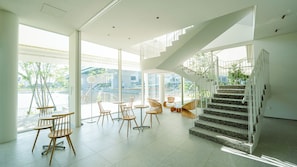 Um interior espaçoso com escada moderna, janelas amplas e áreas de estar.