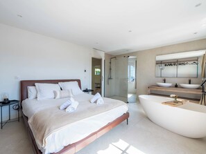 A modern bedroom with a large bed, a walk-in shower, and a freestanding bathtub. - 155m² Villa – Sea View & Swimming Pool (Vallauris)