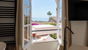 A room with a large window, a television, and a view of the sea. - 155m² Villa – Sea View & Swimming Pool (Vallauris)